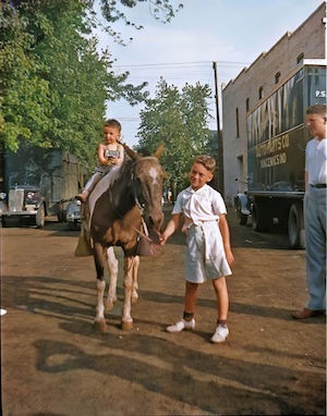 Melvin Shapiro on Nellie, Stan Dumes' pony.  Stan Dumes standing on right. (~1936)